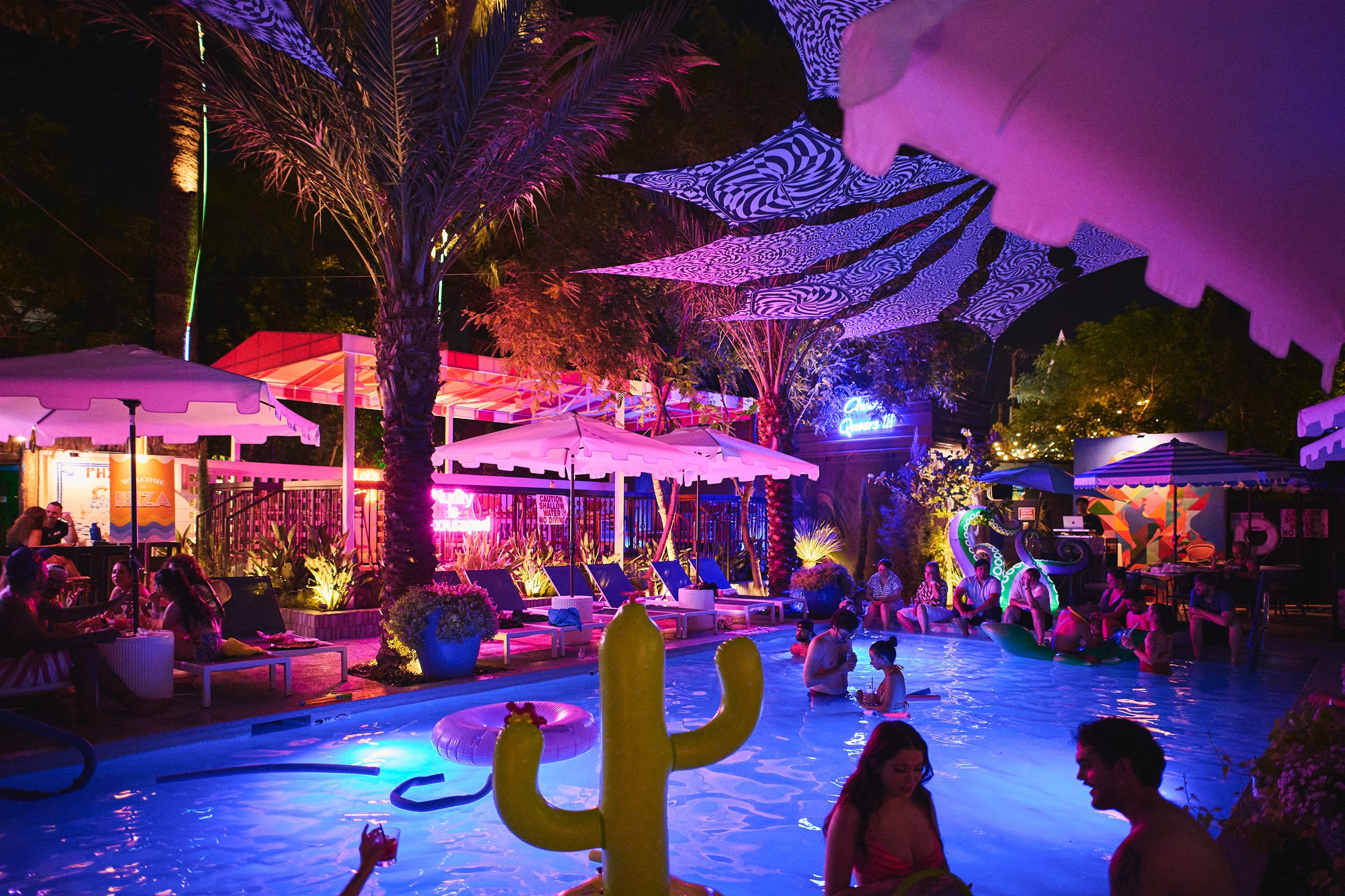 Guests gathering around the illuminated pool at The Pemberton at night